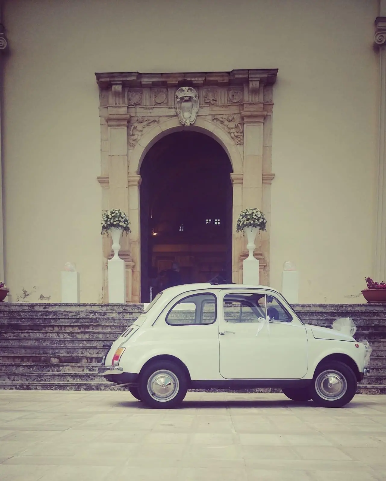 Classic Italian wedding car before an historic venue